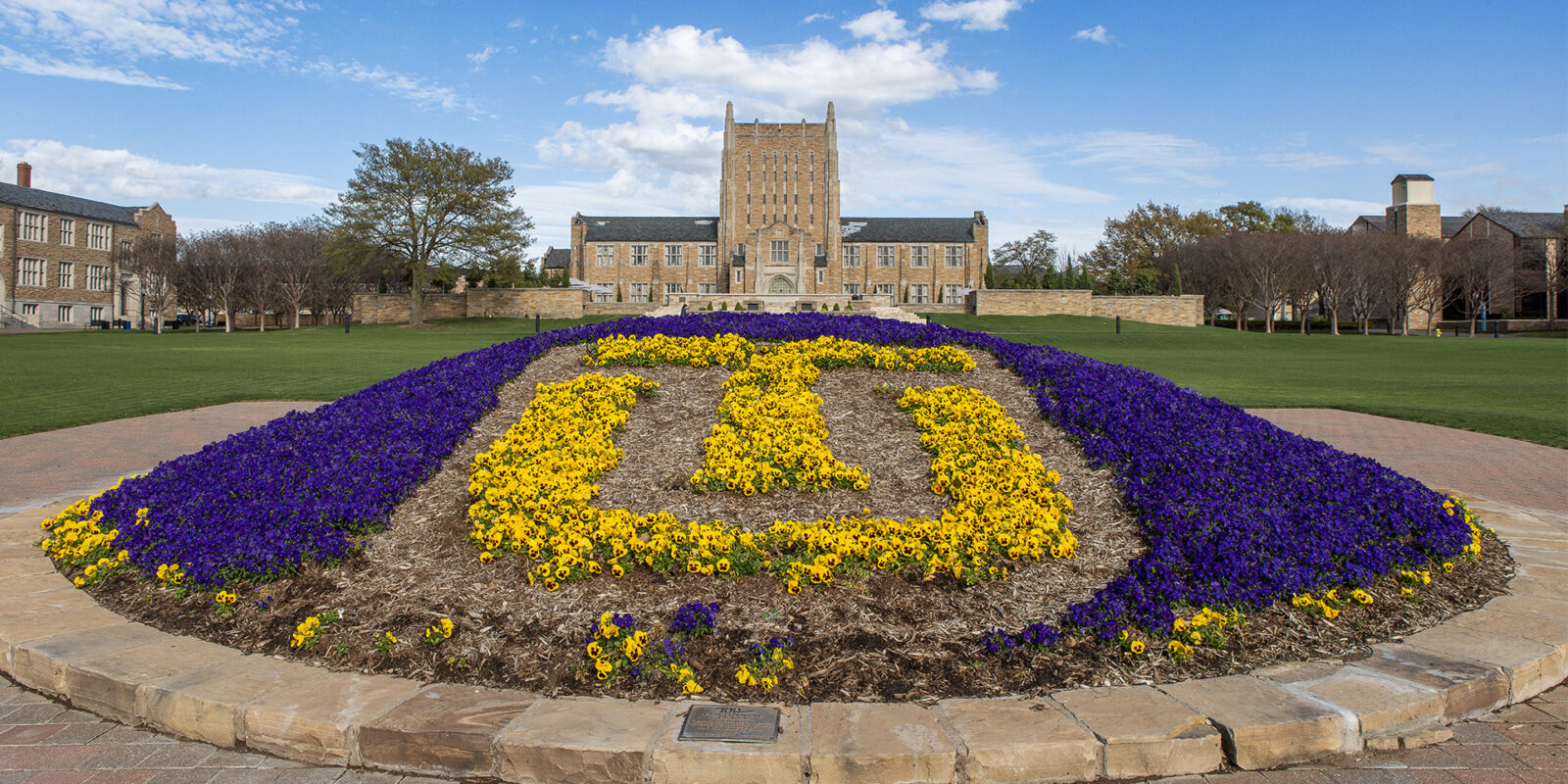 Home-1 Colorful landscaped logo in front of The University of Tulsa buildings in yellow and purple