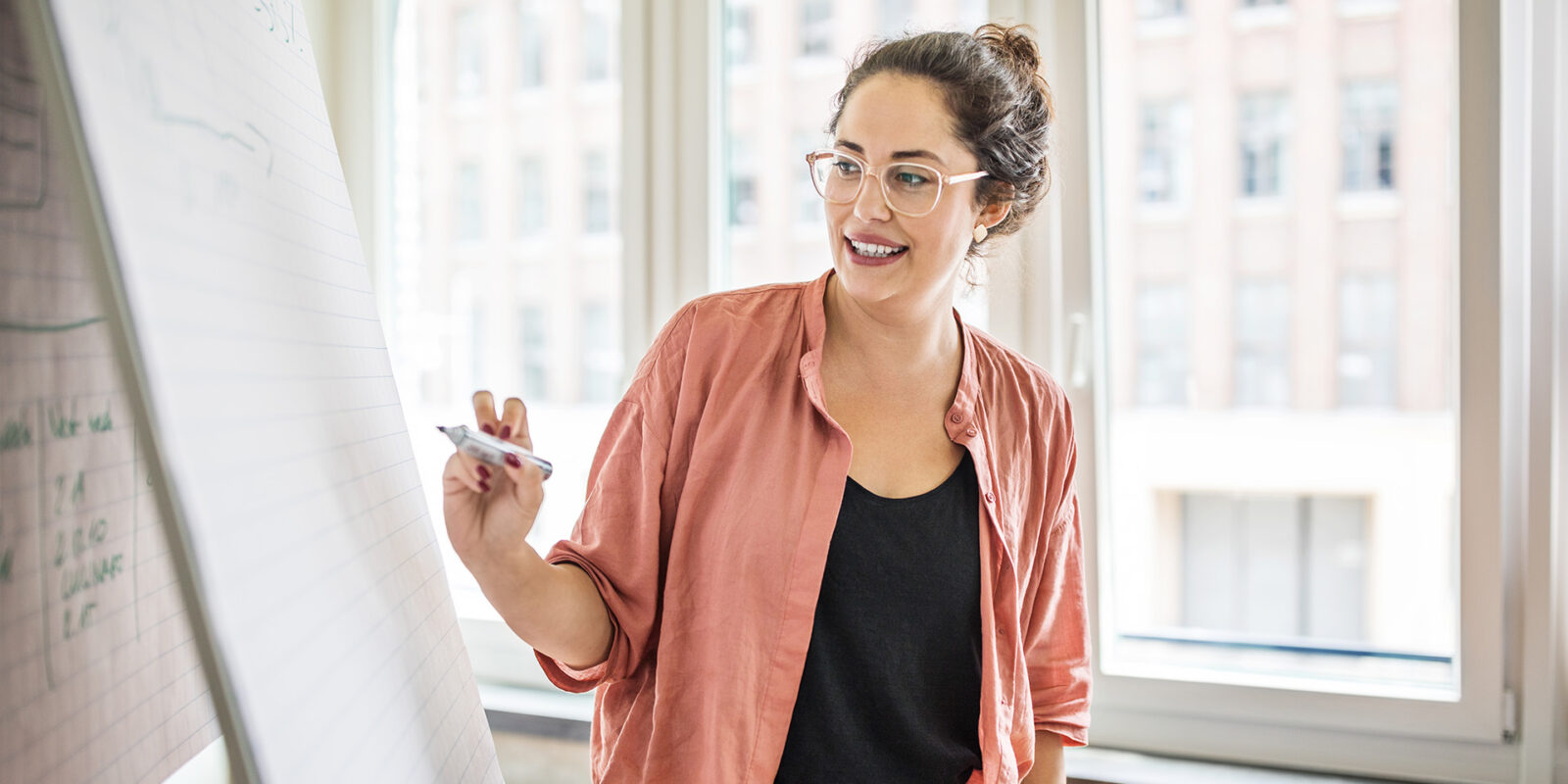 Marketing student standing at easel with large pad of lined paper