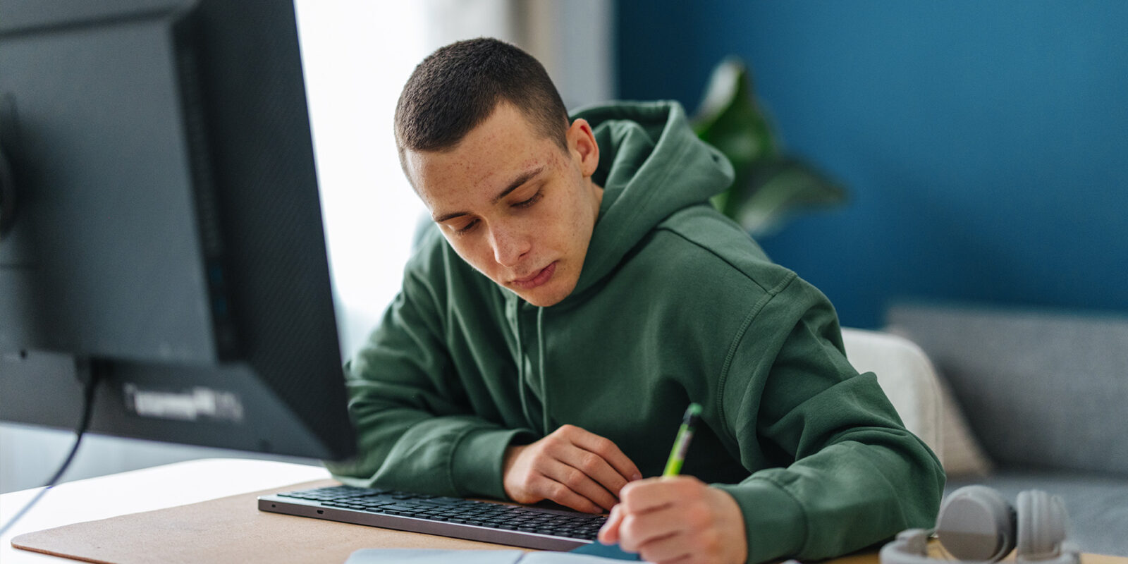 OnlineExperience-1 Student in green sweatshirt working at desk